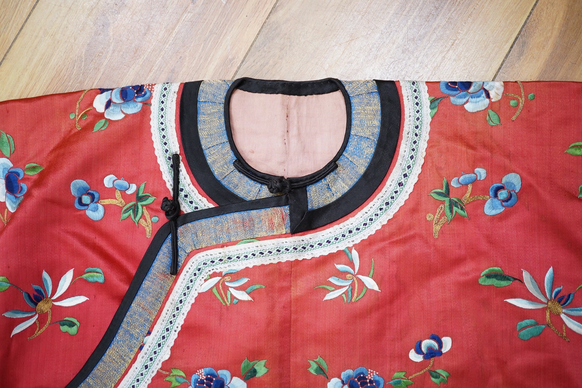 A Chinese embroidered fan case, a small red silk embroidered robe, trousers and a later pair of embroidered slippers, the robe possibly for a child, 20th century, embroidered with multi-coloured flowers and gold thread o